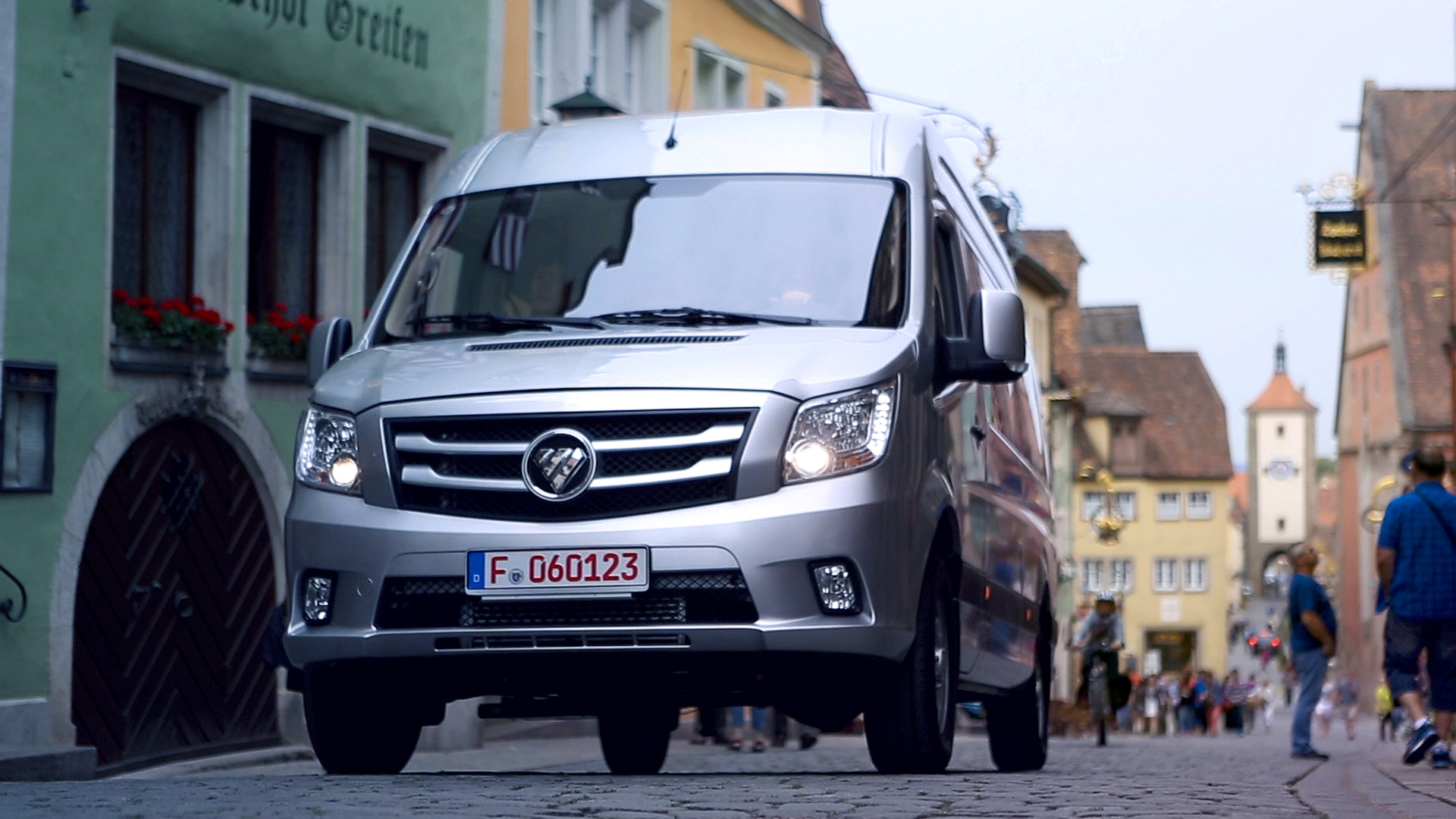 Van FOTON eToano Pro podczas jazdy po miejskiej ulicy w zabudowie starego miasta